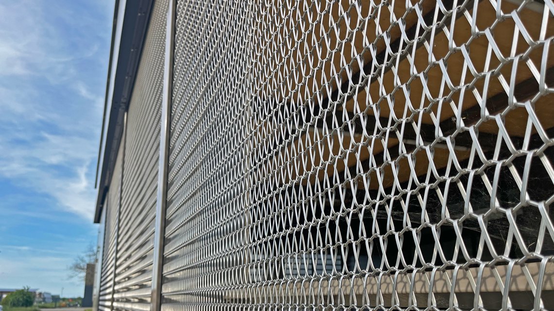 Façade métallique Aéroport Valence @maillemetaldesign - <p>Façade d’une partie du bâtiment de l’aéroport de Valence-Chabeuil en maille métallique spiralée fabriquée sur mesure, en acier inoxydable 316L.</p>