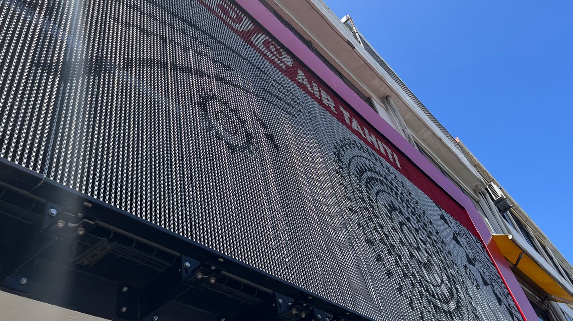 Façade des bureaux Air Tahiti en chaînes à maillons aluminium design by kriskadecor  - <p>Façades des bureaux Air Tahiti situés à Papeete et habillées sur mesure par les chaînes à maillons Kriskadecor avec le système de fixation et de tension KDC Thin System.</p>