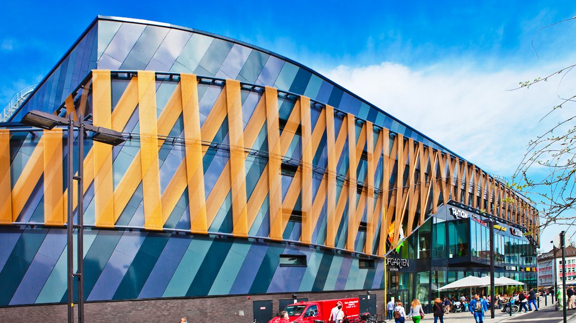 façade moderne d'un centre commerciale revêtue de bandeaux de maille métallique câblée. La maille métallique STAURN est composée de câbles inox et de tiges métallique inox recouvertes d'une couche de peinture plastifiée. - <p>façade moderne d’un centre commerciale revêtue de bandeaux de maille métallique câblée. La maille métallique STAURN est composée de câbles inox et de tiges métallique inox recouvertes d’une couche de peinture plastifiée.</p>