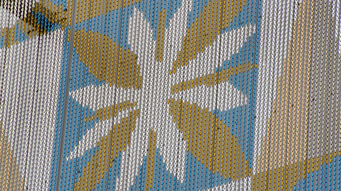 Motif floral stylisé – Impression sur chaînes Kriskadecor - <p>Gros plan sur un motif floral reproduit en impression sur maillons anodisés Kriskadecor. Chaque maillon fonctionne comme un pixel, permettant une reproduction fidèle et durable sur façade extérieure.</p>