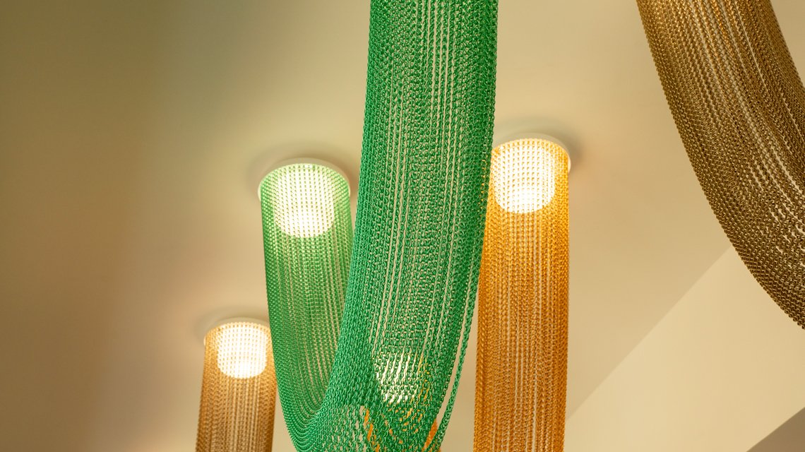 Luminaire décoratif en chaînes à maillons aluminium - <p>Luminaire architectural réalisé avec des chaînes à maillons aluminium Kriskadecor créant un effet de lumière et de transparence.</p>