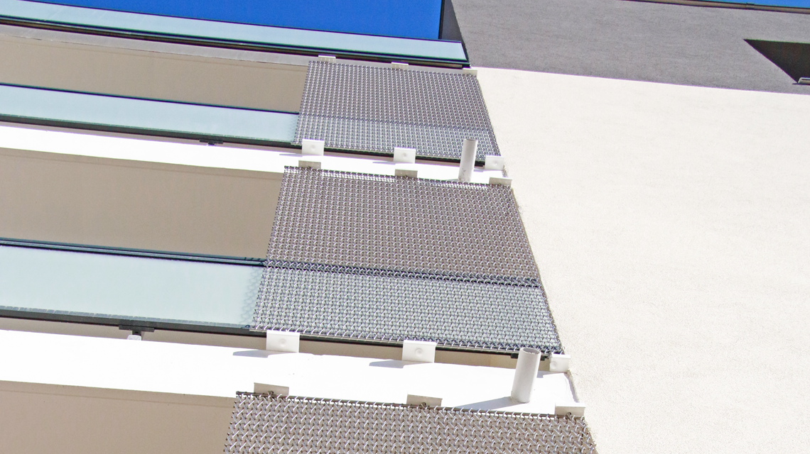 Maille métallique spiralée inox CODERCH www.maillemetaldesign.fr - <p>façade de bâtiment résidentiel avec un habillage en maille métallique spiralée inox</p>