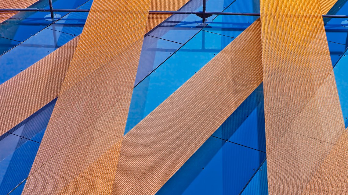 Façade architecturale moderne et personnalisée pour le centre commercial de solingen maille métallique câblée colorée www.maillemetaldesign.fr - <p>façade moderne d’un centre commerciale revêtue de bandeaux de maille métallique câblée. La maille métallique STAURN est composée de câbles inox et de tiges métallique inox recouvertes d’une couche de peinture plastifiée.</p>