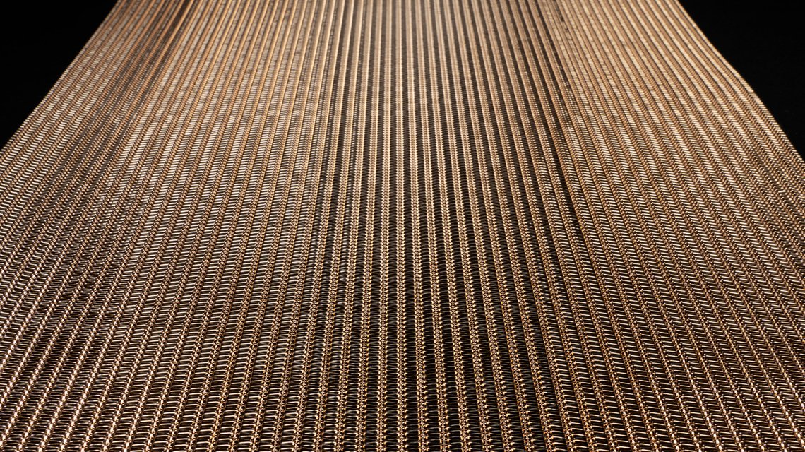 MINI RIVER BRONZE – Texture de maille métallique décorative en bronze - <p>Détail de la texture de la maille MINI RIVER BRONZE mettant en valeur son aspect métallique et sa structure ajourée. Cette maille souple associe légèreté visuelle et esthétique du bronze pour les projets de décoration intérieure, de mobilier design et d’agencement architectural.</p>